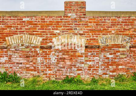 Bricked off doorways with arches on destroyed exterior of building with no roof Stock Photo