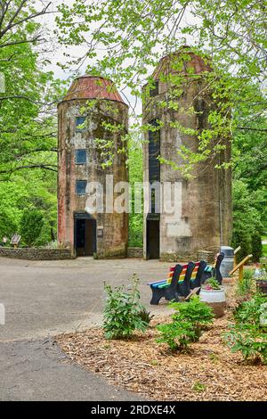 Two silos in Bernheim Forest park with nearby rainbow benches and woods in summertime Stock Photo