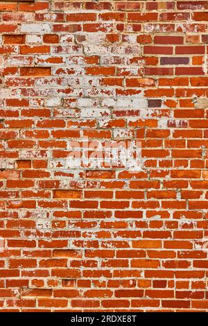 Orange and red brick wall with busted white bricks vertical background asset Stock Photo
