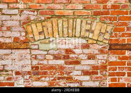 Decaying wall of red bricks coated in white textured paint and filled in doorway background asset Stock Photo