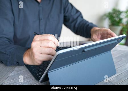 Businessman working on his tablet, close up view. Home environment. Stock Photo