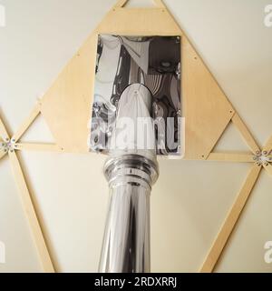 The ceiling with a chimney pipe from the stove in a round house in the form of a geodesic dome Stock Photo