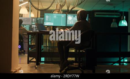 Male spy creating breach of security after gaining access to network system, hacking computer to steal government information. Man doing hacktivism work, ransomware and identity theft. Stock Photo