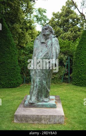 Posthumous  bronze sculpture of Honoré de Balzac by  Auguste Rodin framed by conical topiary in the garden setting of Musée Rodin, Paris, France, Stock Photo