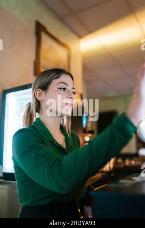 Young waitress working at bar Stock Photo