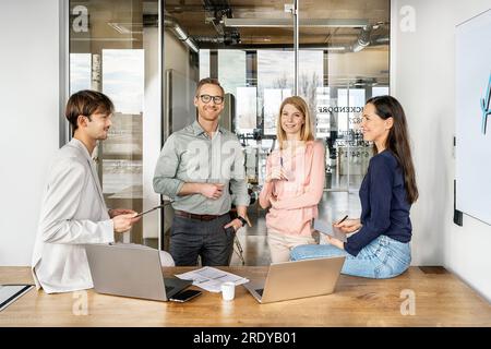 Happy colleagues working and having discussion together Stock Photo