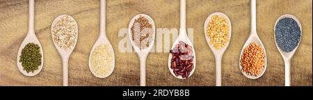 set of wooden spoons filled with various seeds on a scratched wooden background Stock Photo