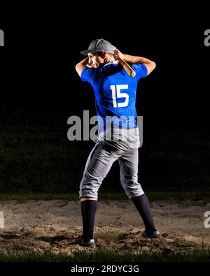 Young man holding baseball bat at night Stock Photo