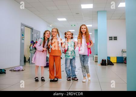 Smiling school students standing together in school corridor Stock Photo