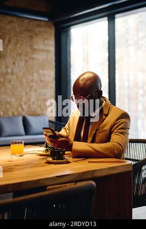 Businessman using smart phone and having lunch at conference table Stock Photo
