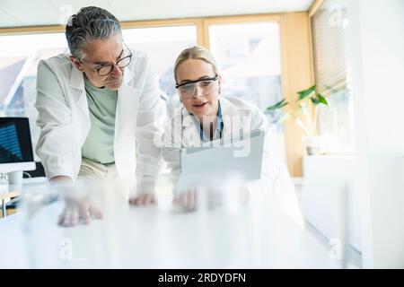 Scientists working on tablet computer in laboratory Stock Photo