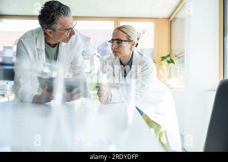 Scientists working on tablet PC in laboratory Stock Photo