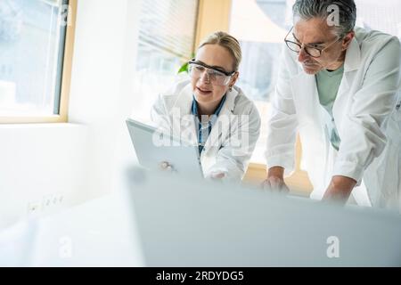 Scientists working with tablet computer in laboratory Stock Photo