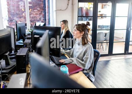 Businesswomen working on desktop PC in office Stock Photo