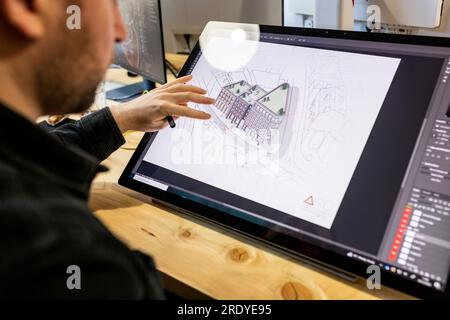Architect working and examining drawing on graphics tablet Stock Photo