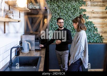 Smiling businessman talking to colleague in office cafeteria Stock Photo