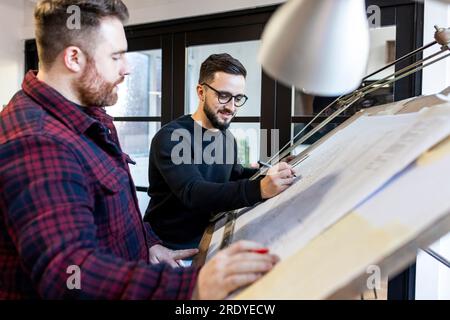 Architects working on blueprint in office Stock Photo