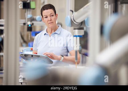 Mature technician testing machine part using equipment in industry Stock Photo