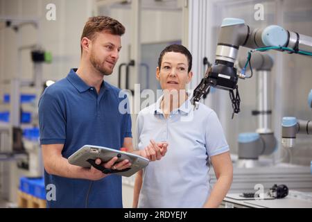 Engineers discussing together standing in modern factory Stock Photo