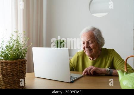 Senior woman using laptop on table at home Stock Photo