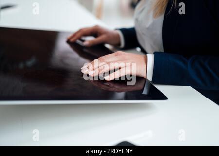 Hands of businesswoman working on graphics tablet in office Stock Photo