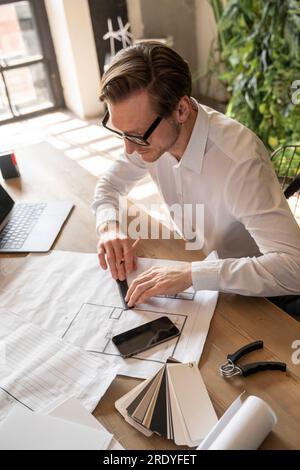 Architect measuring on blueprint and working in office Stock Photo