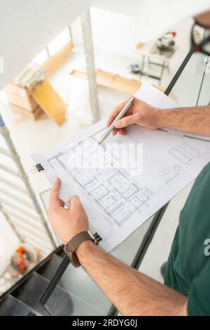 Hands of architect working on blueprint at contsruction site Stock Photo