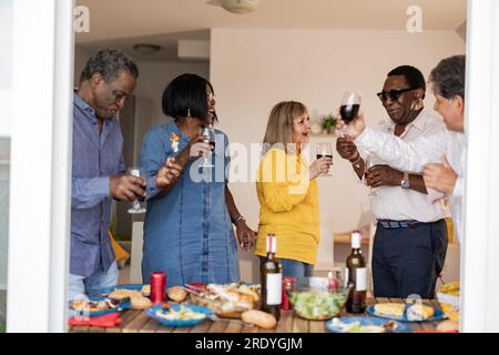 Multiracial senior friends having fun with each other at dinner party Stock Photo