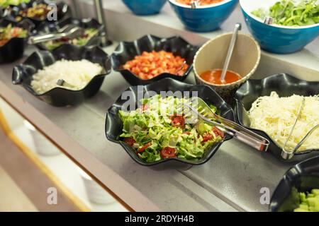 Salads with fresh vegetables in bowls on the buffet table in the hotel restaurant. Stock Photo