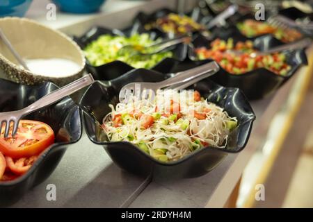 Salads with fresh vegetables in bowls on the buffet table in the hotel restaurant. Stock Photo