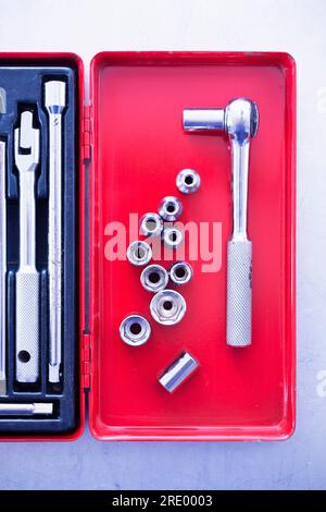 Top view on ratchet drill and socket wrenches in red toolbox Stock Photo