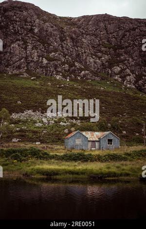 old shed infront of big stone mountain in scottish highlands Stock Photo