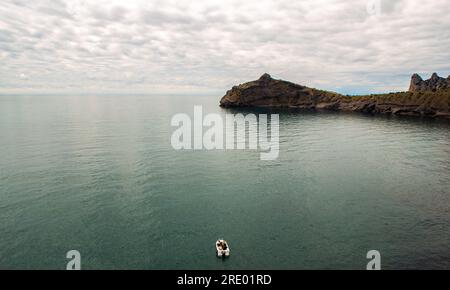 Lonely boat in the Sea Cove with sunset Stock Photo