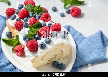 Sponge biscuit cake roll filling whipped cream and berries decorated ...