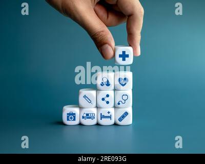 Medical care concept with hand stacking wooden cubes with symbols of ...