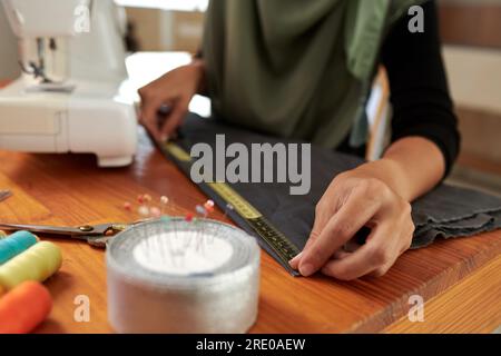 Seamstress using tape measure when working on gown for client Stock Photo