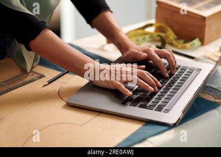Hands of fashion designer answering e-mails from clients Stock Photo