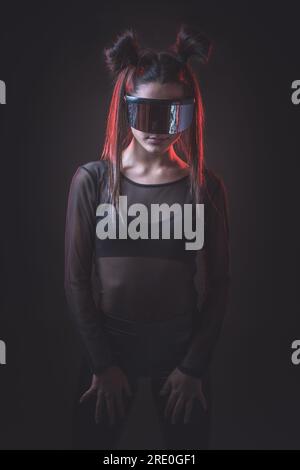 Portrait of beautiful cyber model woman posing wearing futuristic glasses on head with neon light in a virtual tech environment Stock Photo