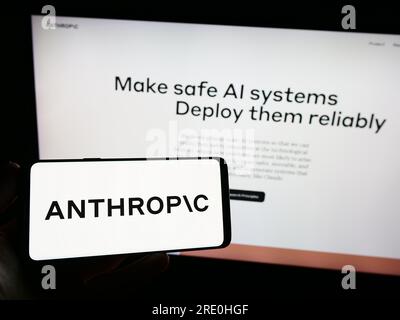Person holding smartphone with logo of US artificial intelligence company Anthropic PBC on screen in front of website. Focus on phone display. Stock Photo