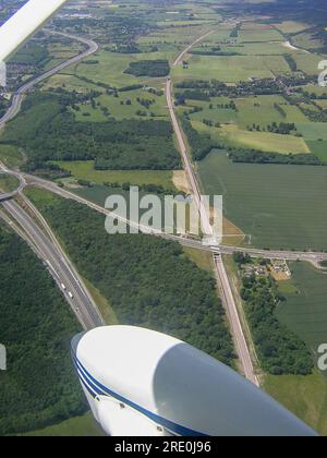 Aerial view looking down on the M20 and high speed railway line near Maidstone and Detling, with a train on the rail cutting. Routes through country Stock Photo