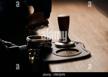 barista holding tamper above portafilter with grinded coffee, espresso, manual  press, arabica Stock Photo by LightFieldStudios