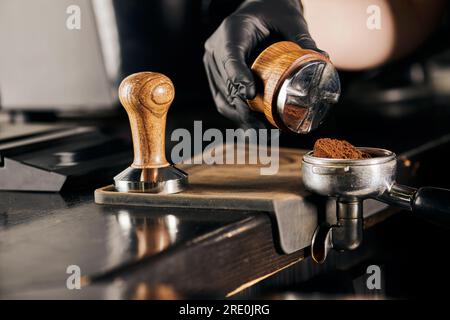 barista holding tamper near portafilter with grinded coffee, espresso, manual  press Stock Photo by LightFieldStudios