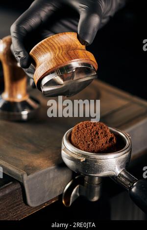 barista holding tamper above portafilter with grinded coffee, espresso, manual  press, arabica Stock Photo by LightFieldStudios