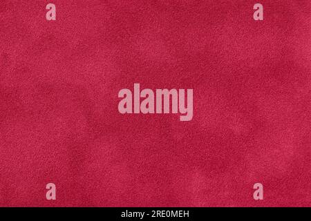Texture of velvet dark red matte background, macro. Suede fabric with wine pattern. Seamless textile leather ruby backdrop, closeup. Stock Photo