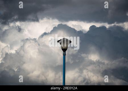 Electric street lamp against contrasty clouds, isolated object Stock Photo