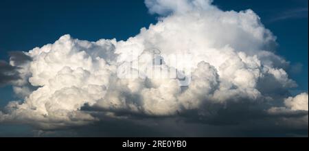 Contrasty scene of huge bright cloud against blue sky, abstract landscape Stock Photo