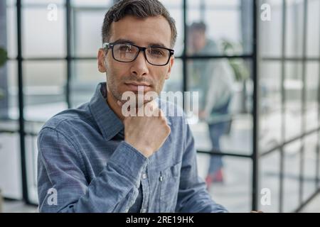 Pensive man in glasses distracted from computer work look in distance thinking or pondering Stock Photo