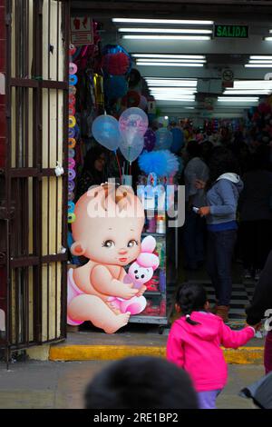 Large cardboard cutout baby in entrance of shop selling things for children in commercial area of central Lima, Peru Stock Photo