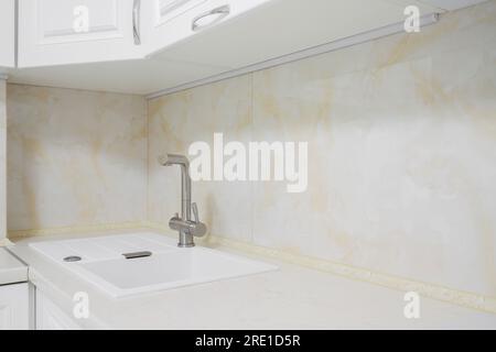 Faucet with white granite sink in the kitchen Stock Photo