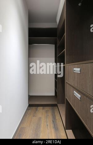 Brown wardrobe with shelves in the dressing room interior Stock Photo